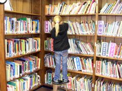 student putting books away